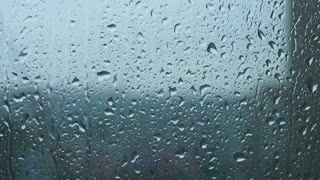 videoblocks-a-heavy-rain-with-gusts-of-wind-pours-through-the-window-streams-of-water-quickly-flow-down-the-glass-summer-hurricane-with-pouring-rain-sounds-of-the-rain_h0aoqvfklz_thumbna